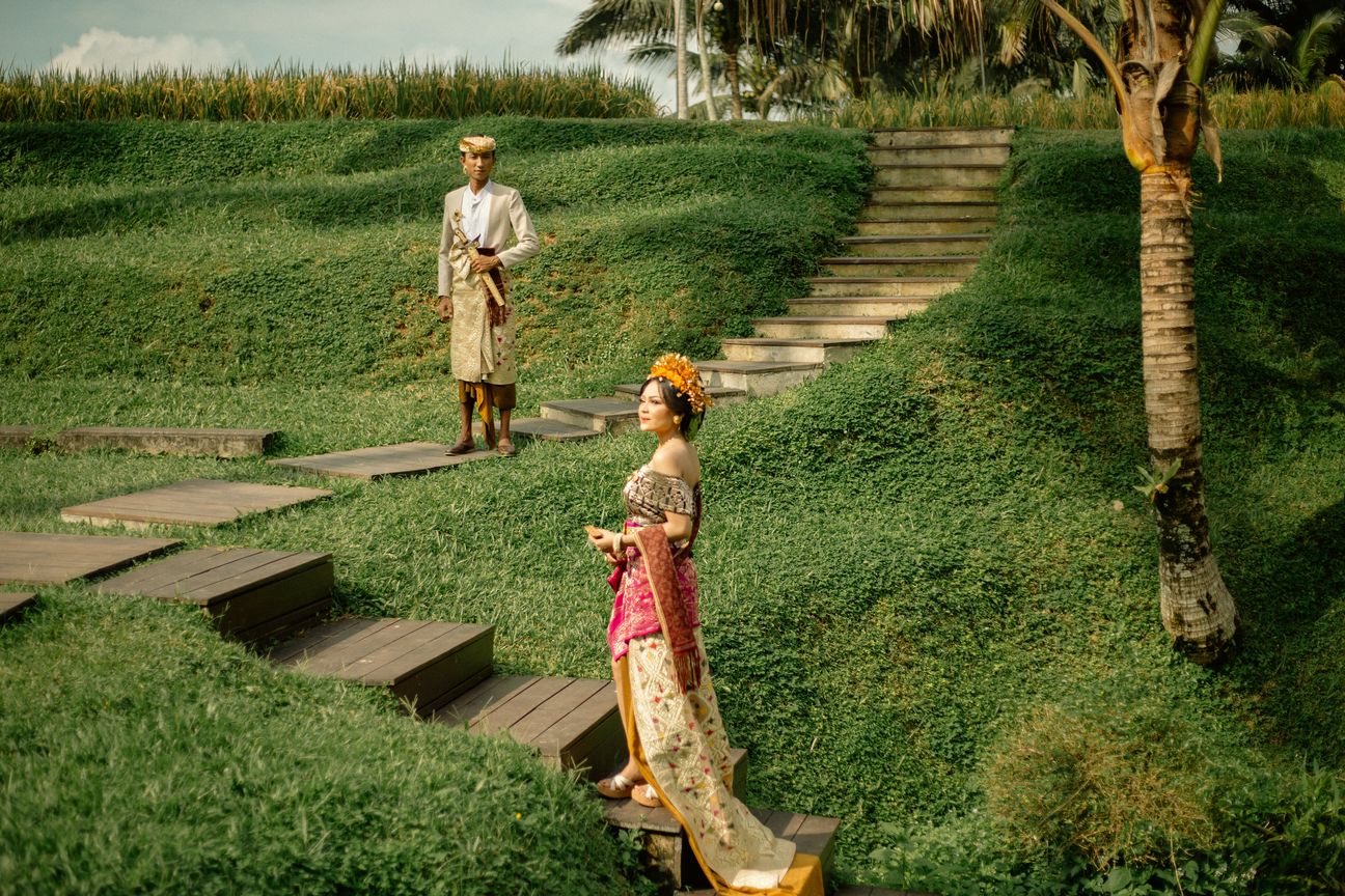 A couple stand together on a modern walkway overlooking green rice terraces