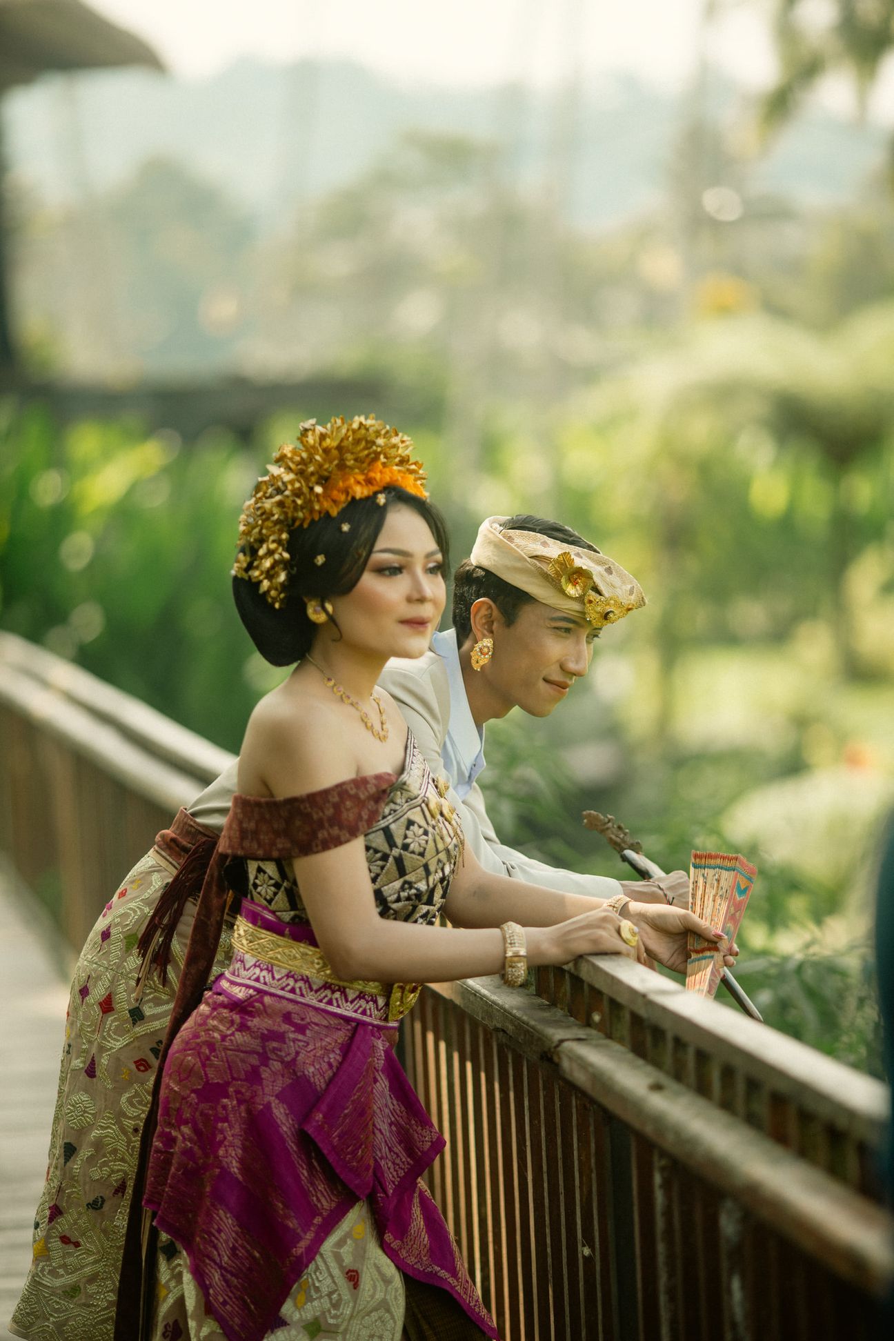 A couple stand together on a modern walkway overlooking green rice terraces