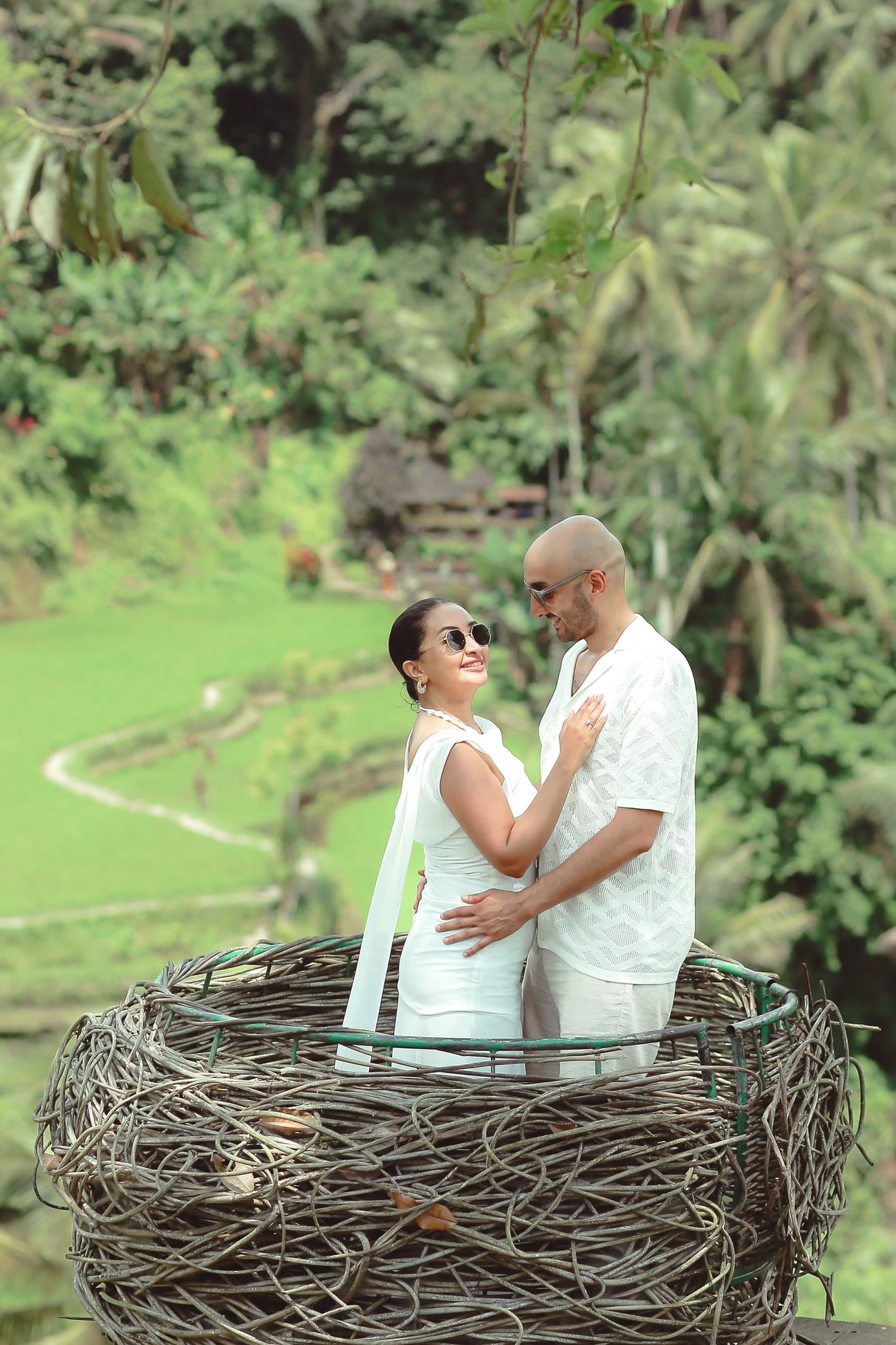 A couple embrace at a woven lookout above the rice terraces