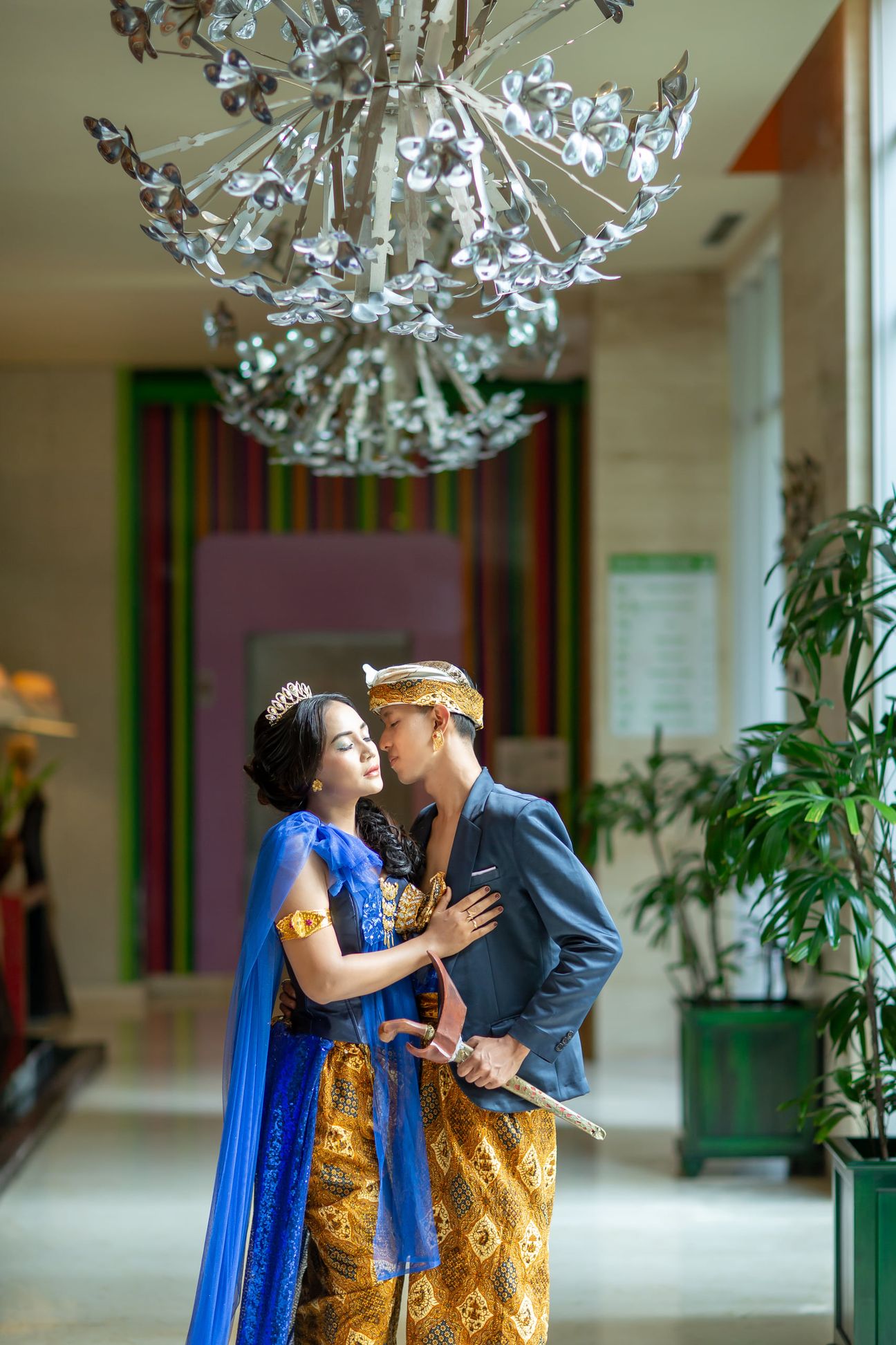 A bride and groom smile together before a floral wedding backdrop