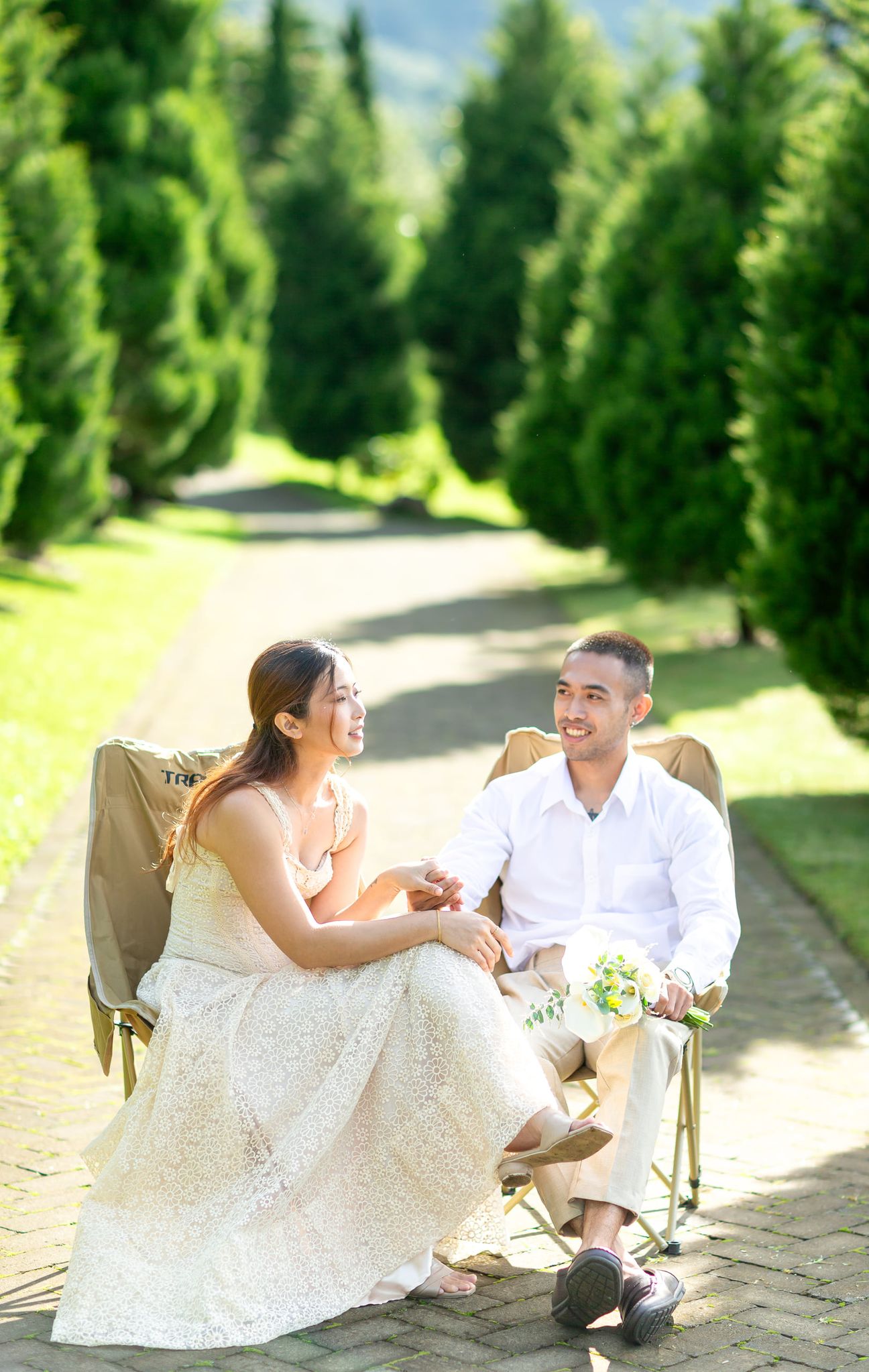 A couple share a laugh by a wooden garden fence surrounded by yellow blooms