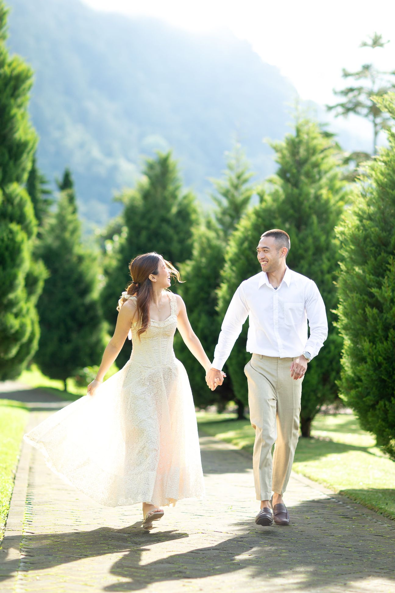 A couple share a laugh by a wooden garden fence surrounded by yellow blooms