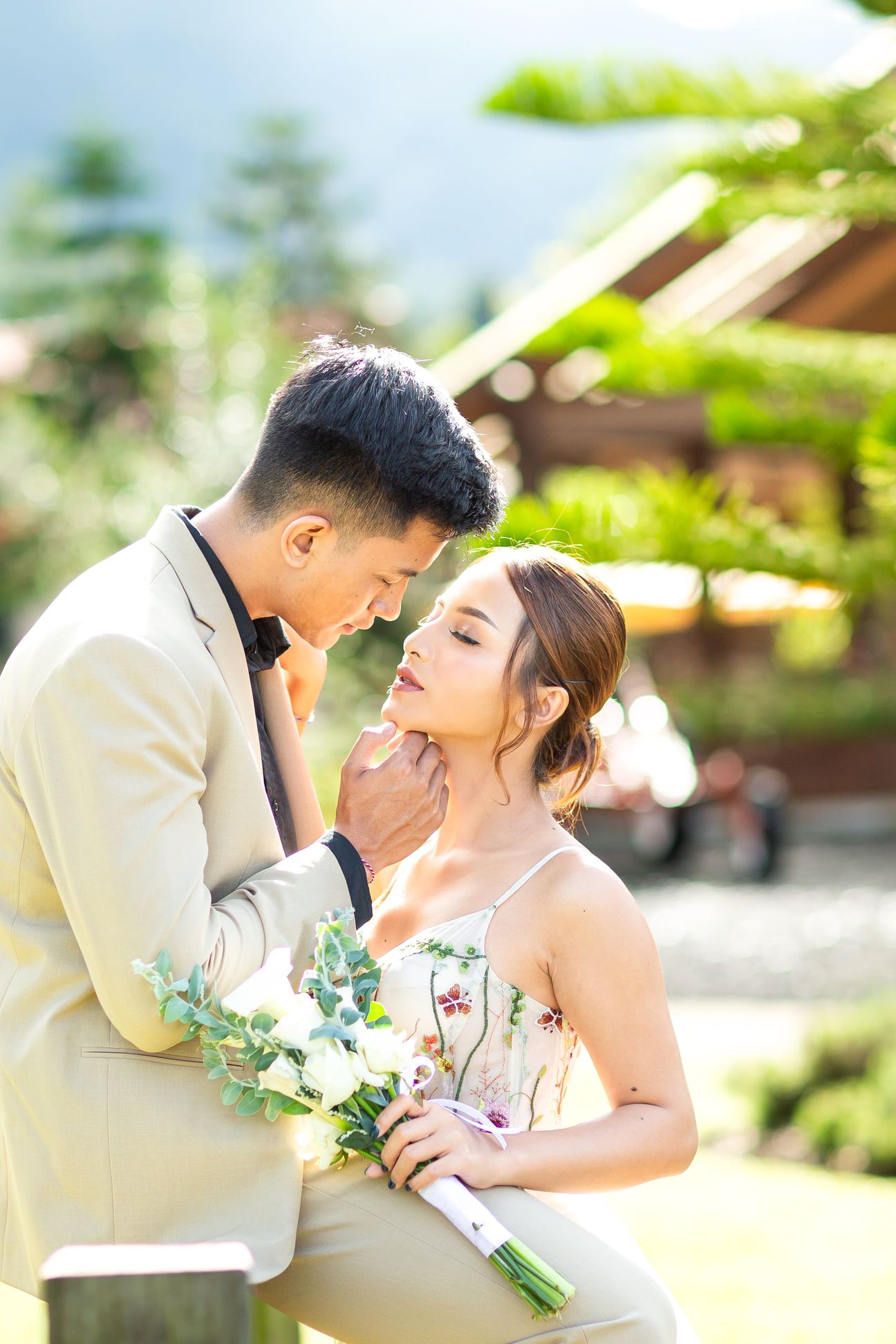 A couple share a laugh by a wooden garden fence surrounded by yellow blooms