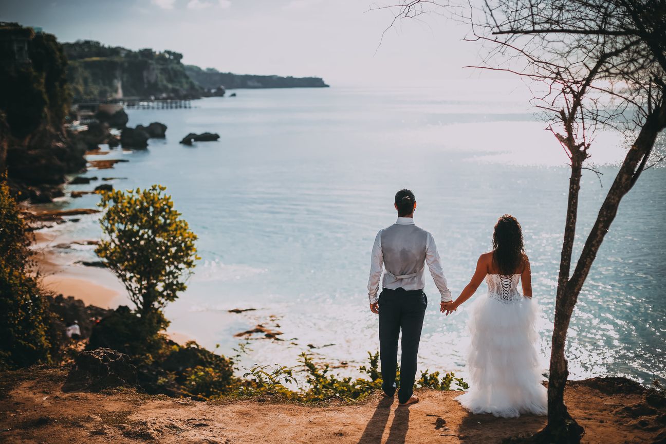 A couple look across the coastline from a high viewpoint