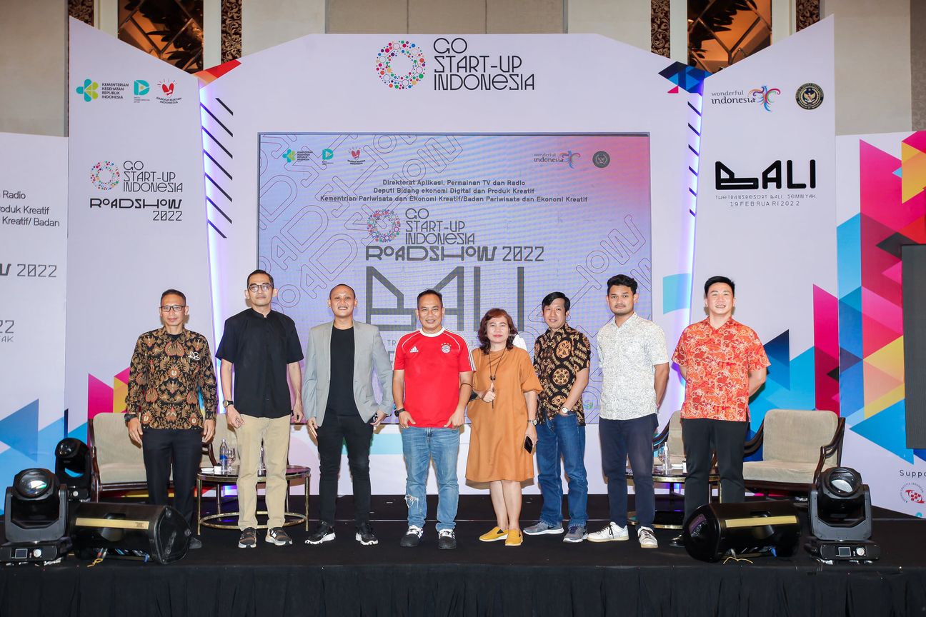 Speakers stand shoulder to shoulder on stage for the closing photograph