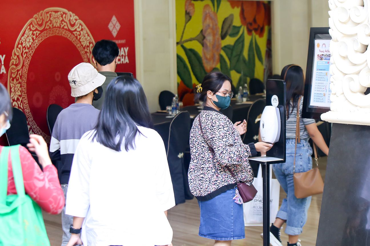 Delegates file past a stand-mounted hand sanitiser on the way into the hall
