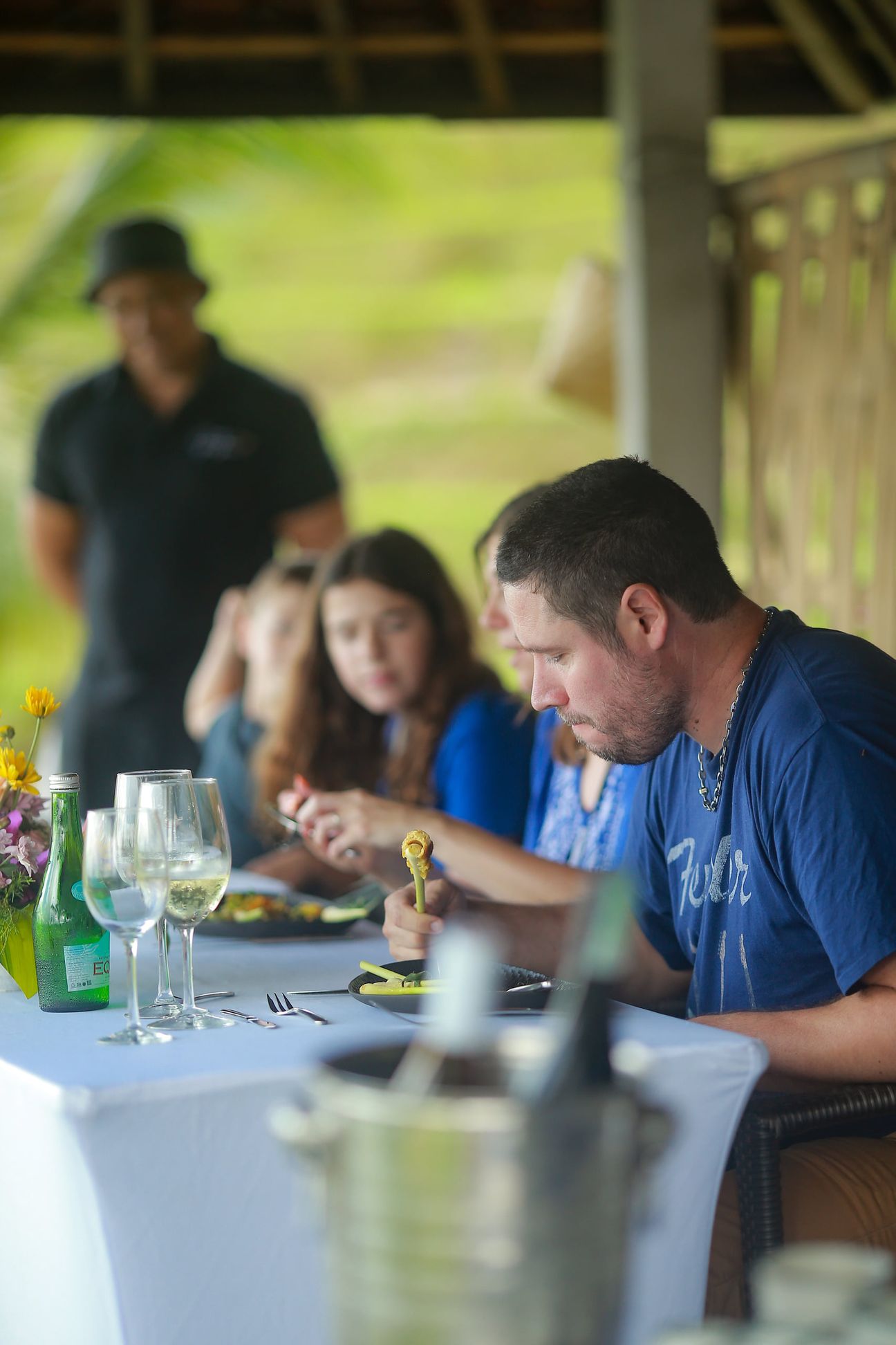 A young boy and his family share relaxed moments at a shaded garden table