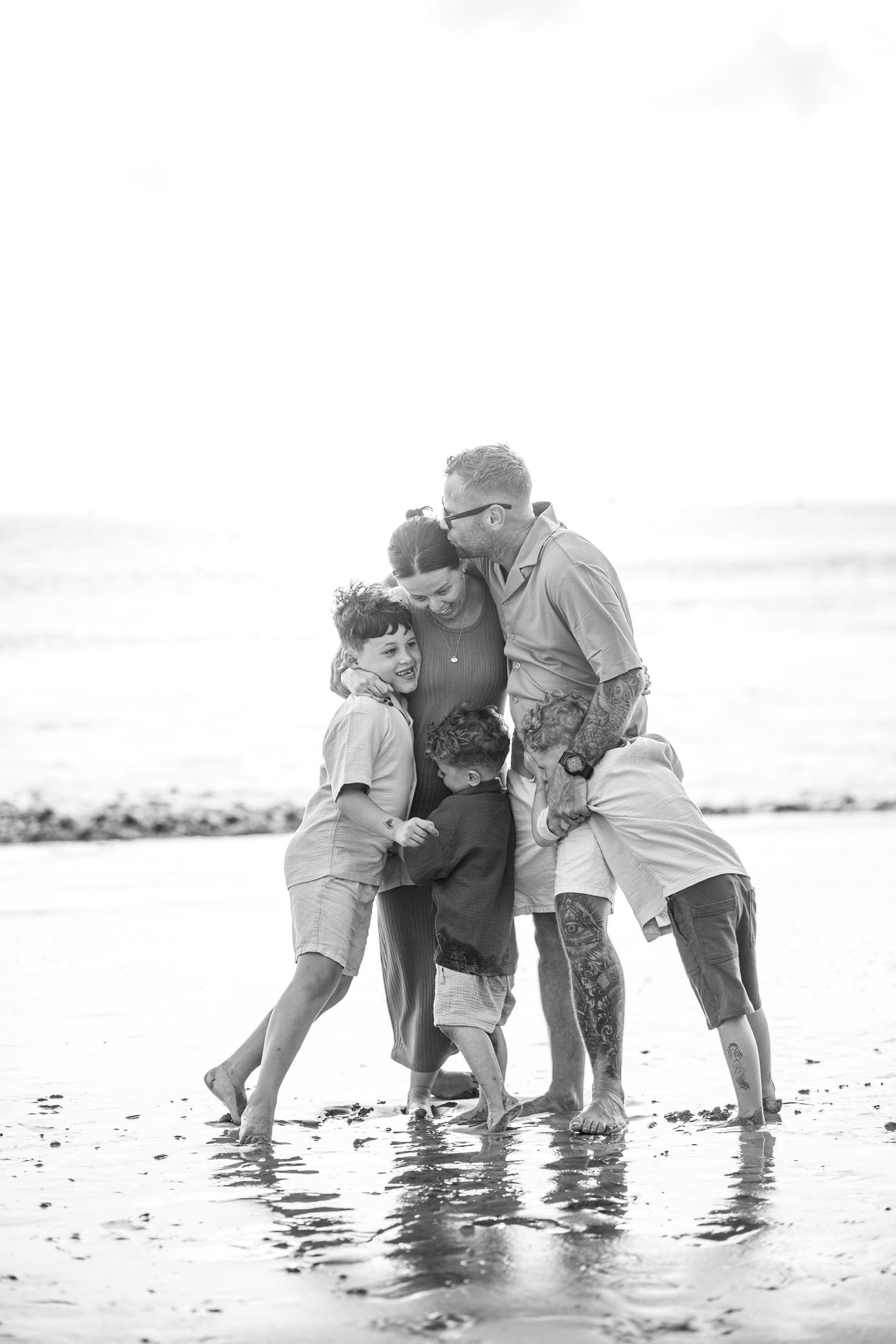 Young children laugh and play together on a bright beach