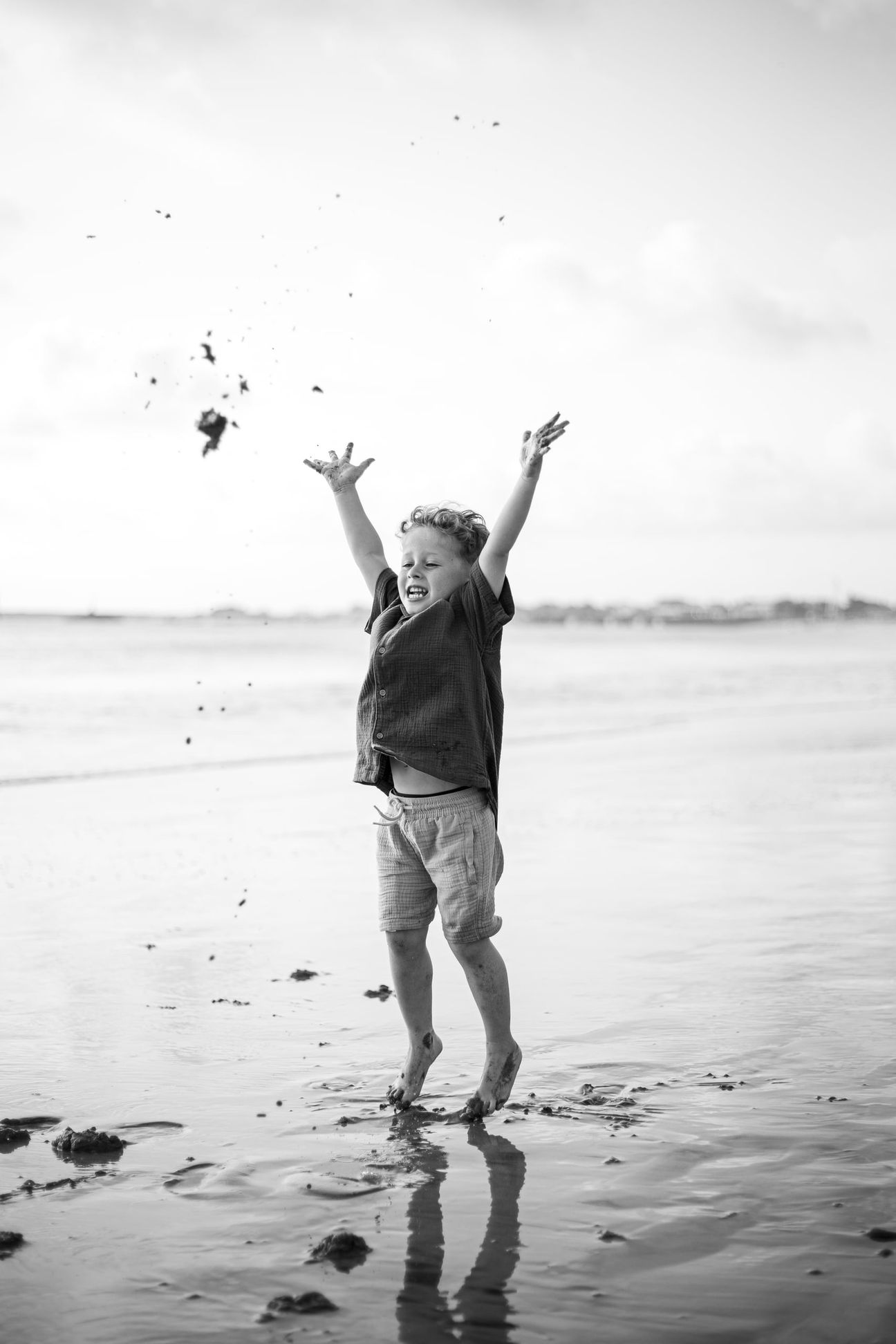 Young children laugh and play together on a bright beach