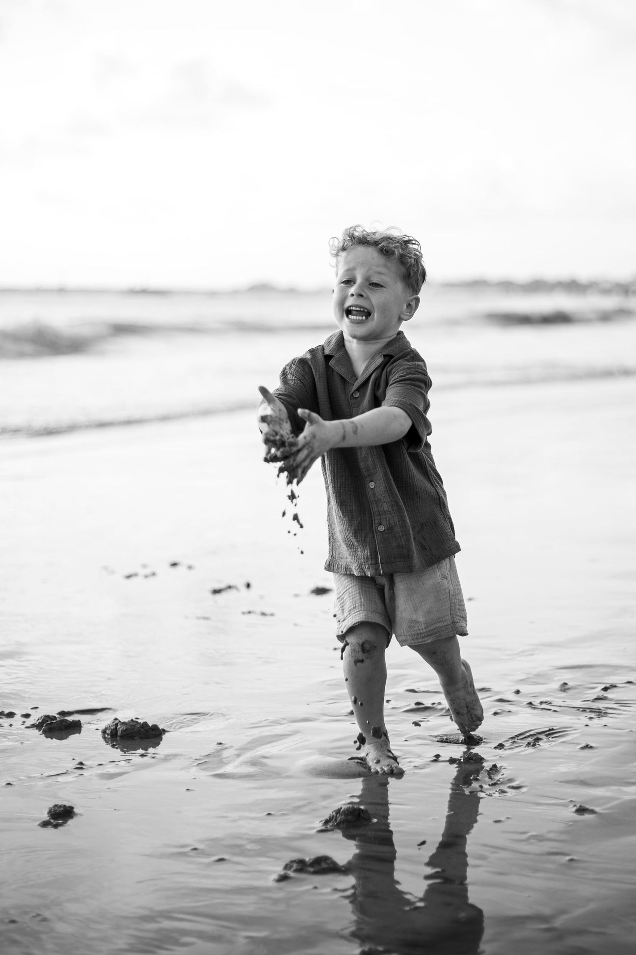 Young children laugh and play together on a bright beach
