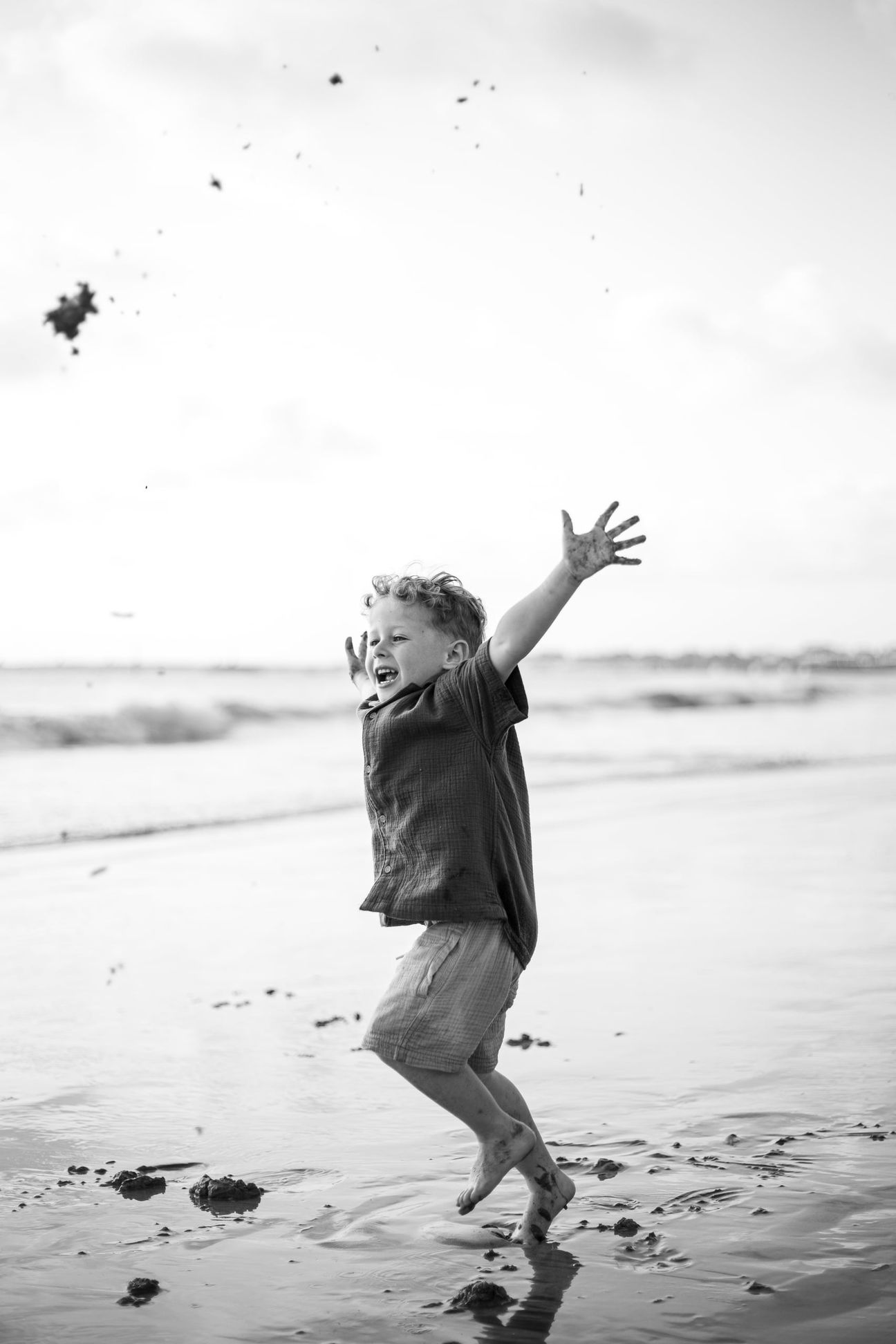 Young children laugh and play together on a bright beach