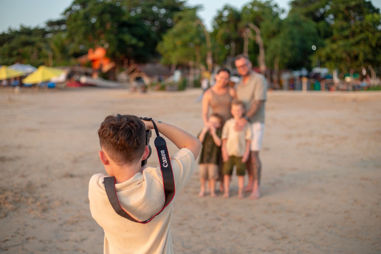 A photographer makes a family portrait on the beach