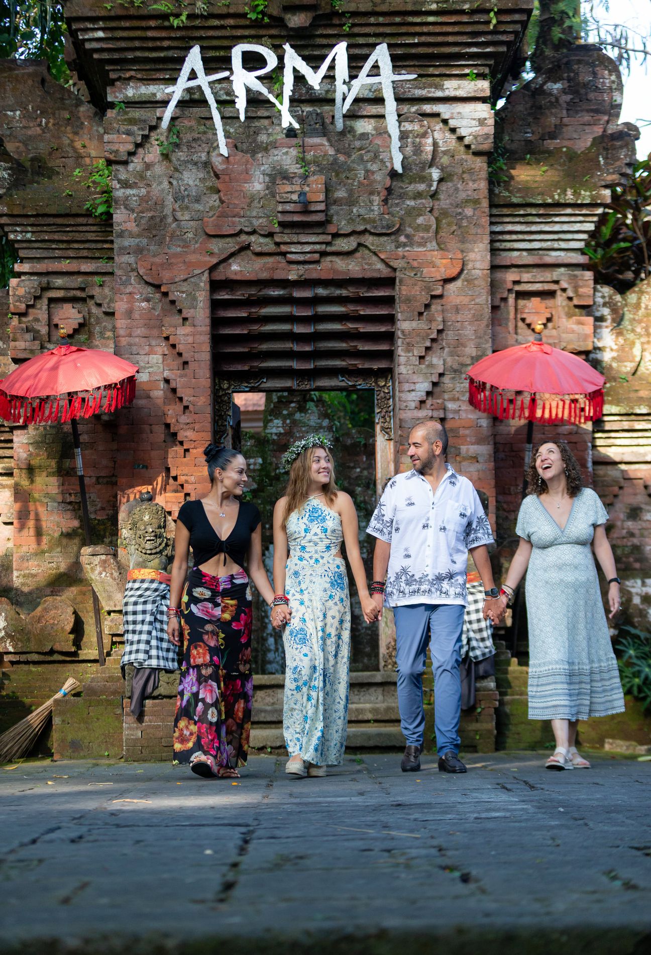 A family group pose together at a traditional Balinese entrance