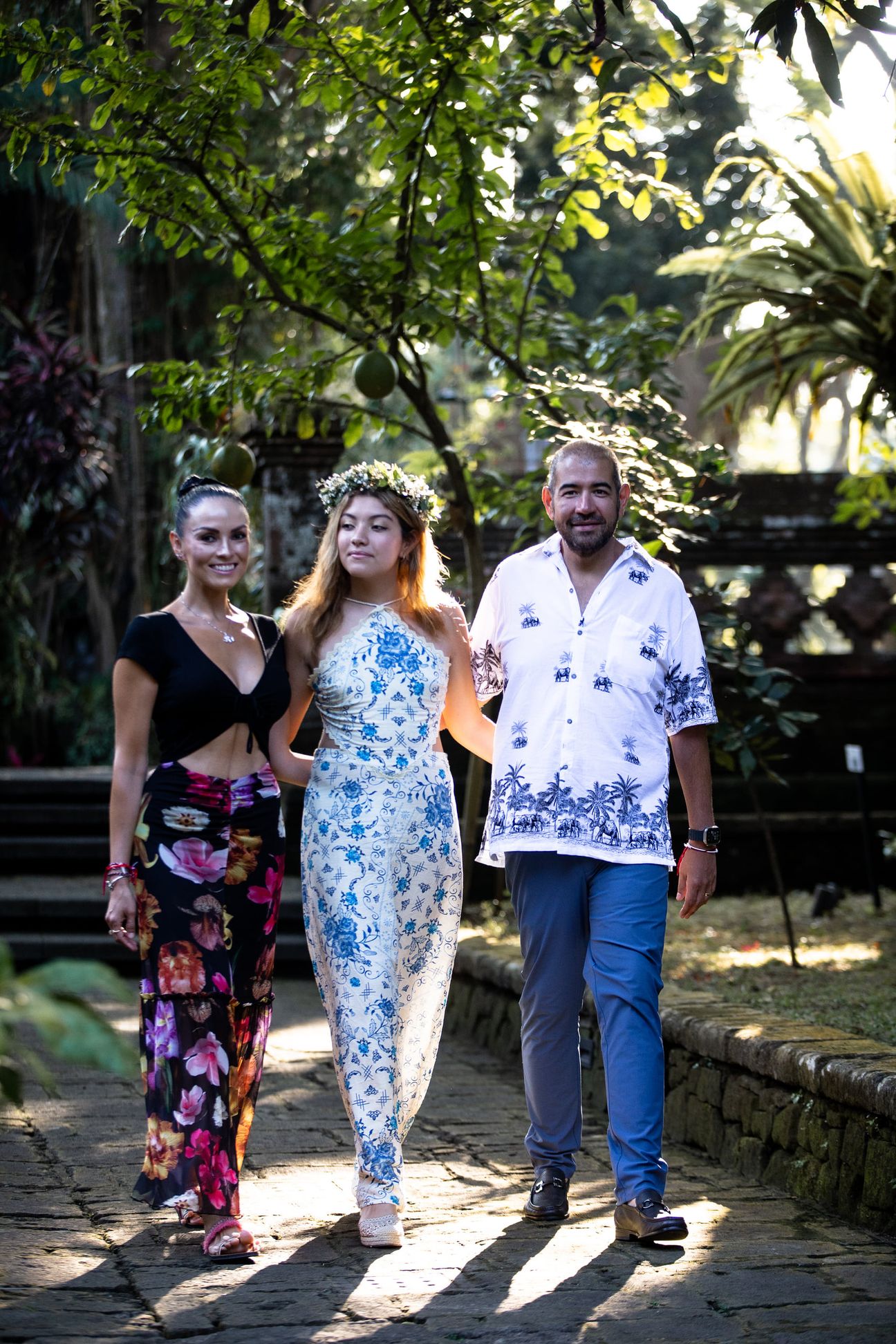 A family walk and sit together in a tropical garden
