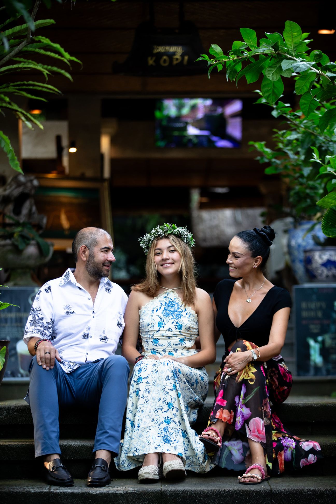 A family walk and sit together in a tropical garden
