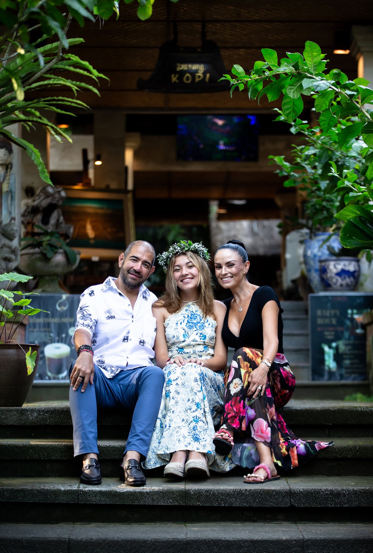 A family walk and sit together in a tropical garden