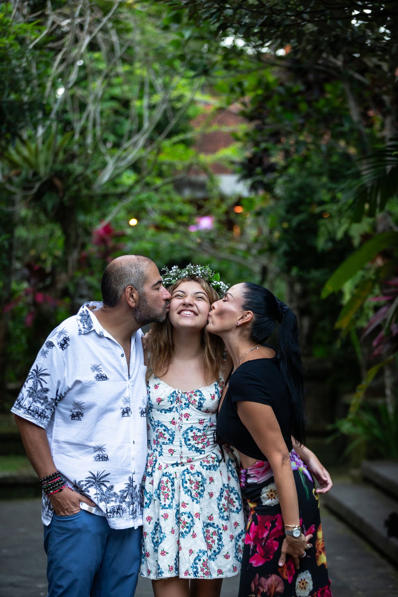 A family laugh together around a shaded garden table