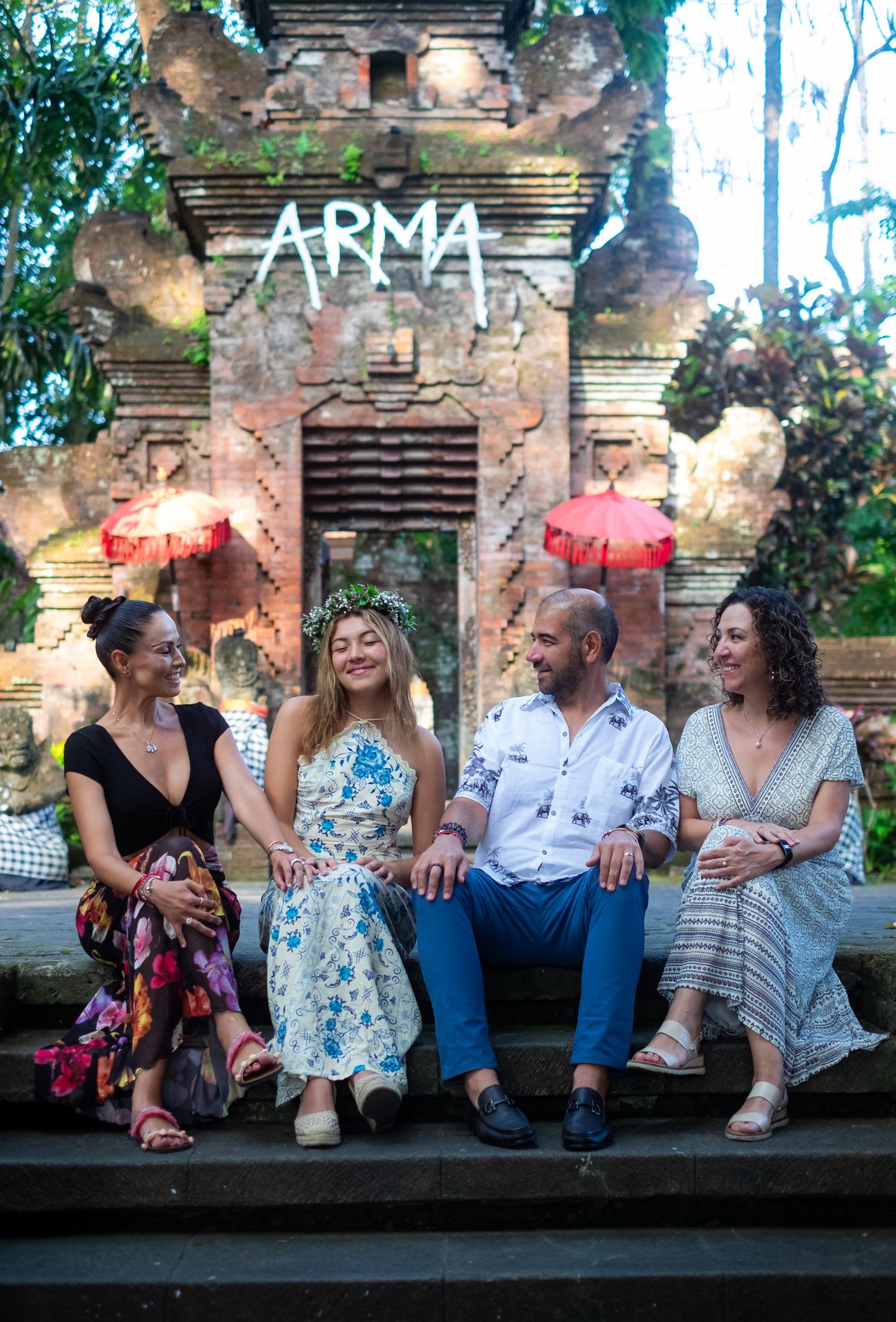 A family group sit together in a Balinese garden