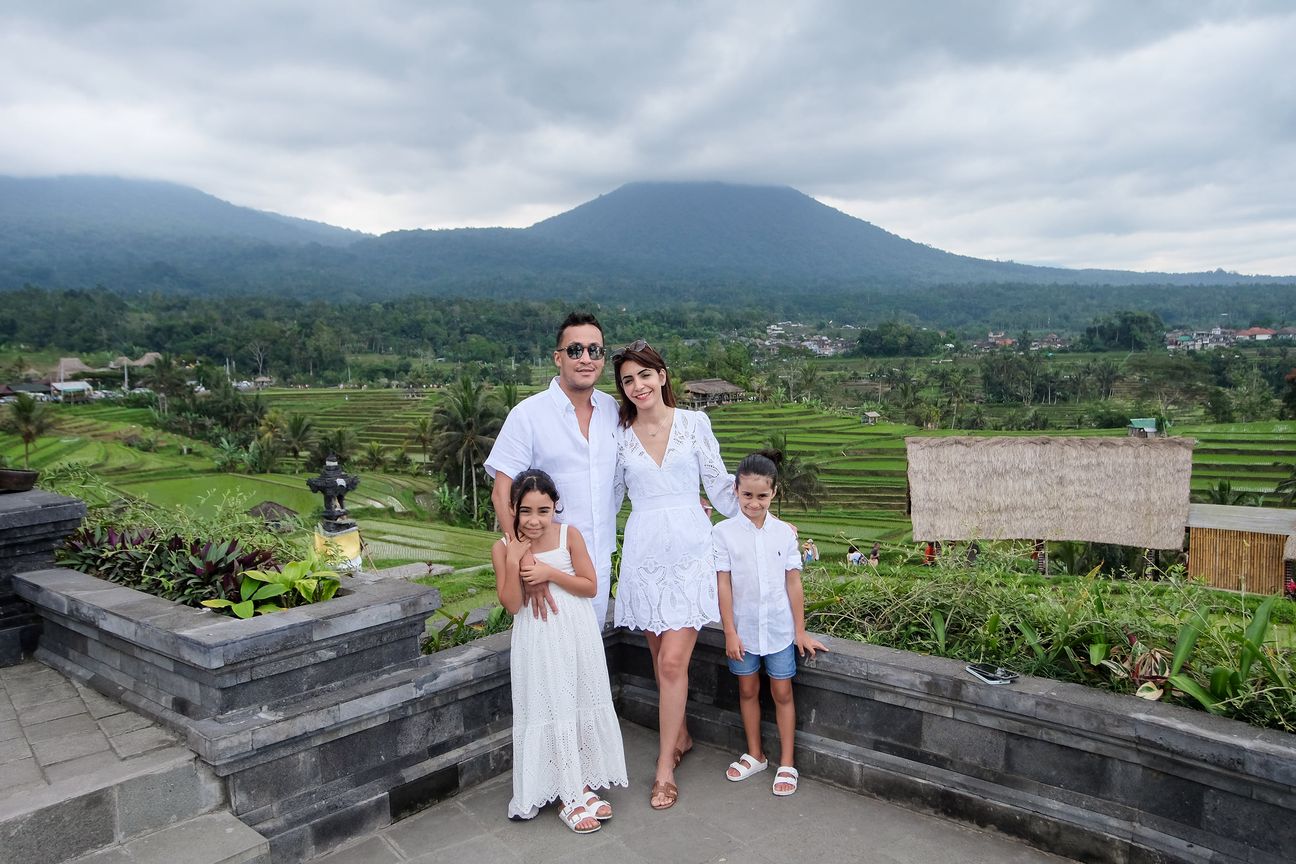A family of four dressed in white pose together among the rice terraces