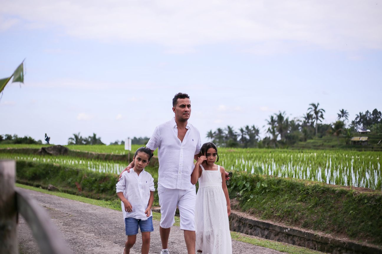 A family of four dressed in white pose together among the rice terraces