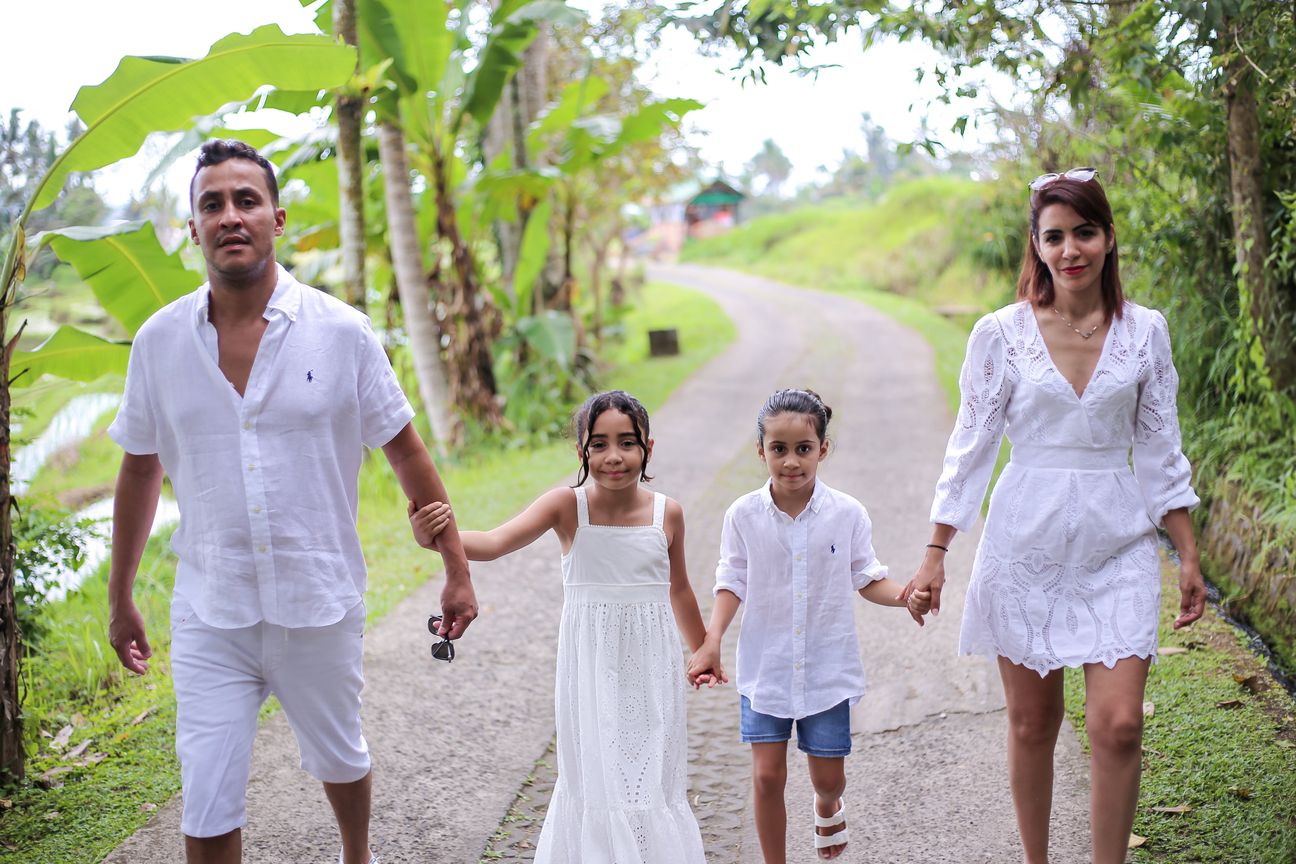 A family dressed in white walk the paths between the rice terraces