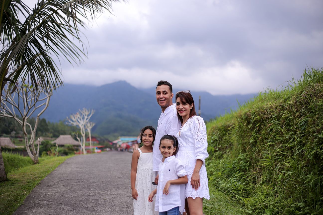 A family of four dressed in white pose together among the rice terraces