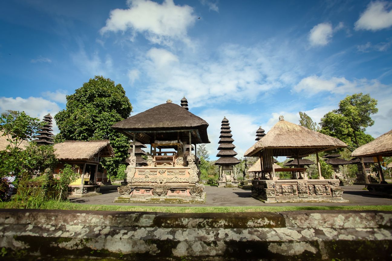 A visitor walks through a traditional Balinese temple complex
