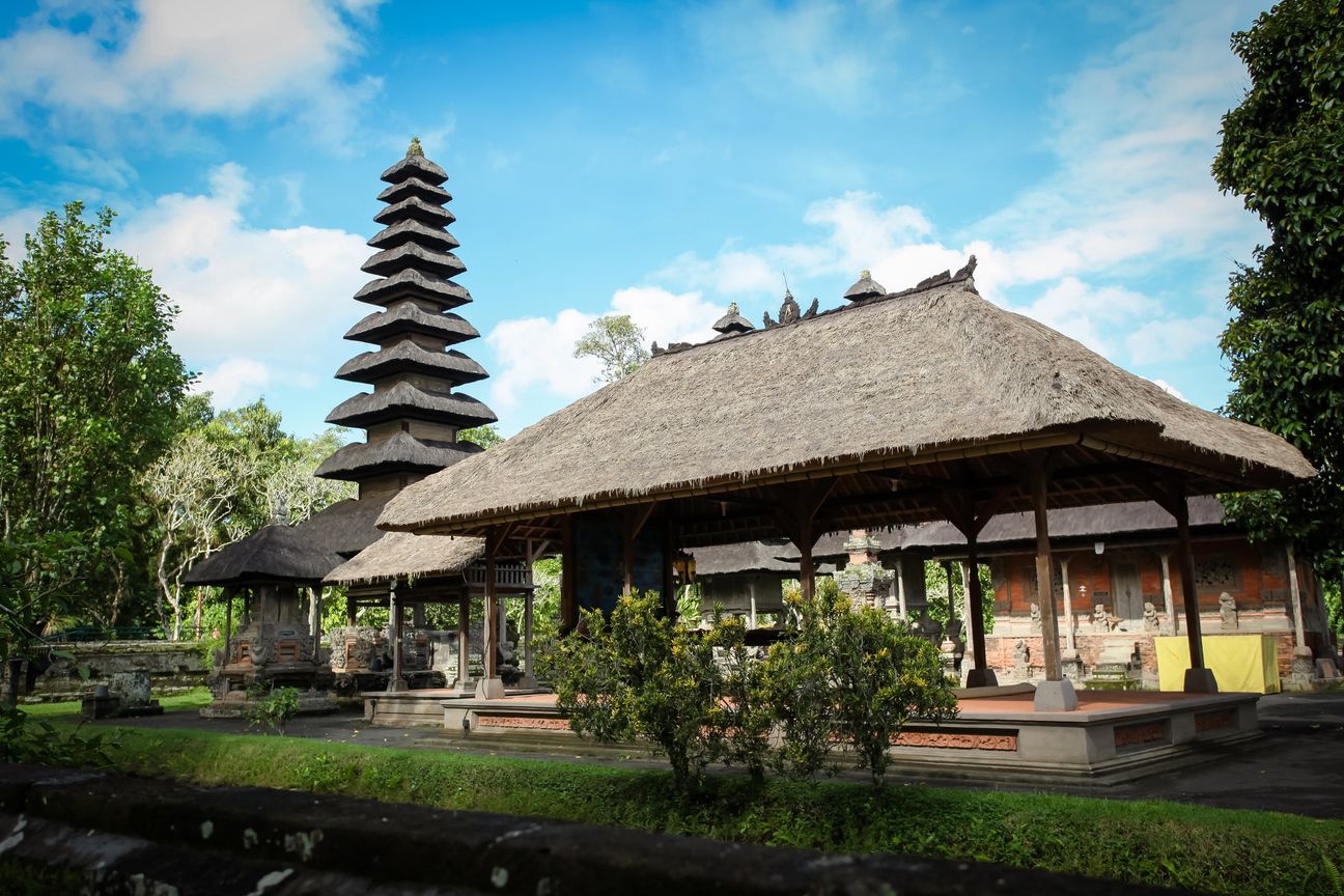 A visitor walks through a traditional Balinese temple complex