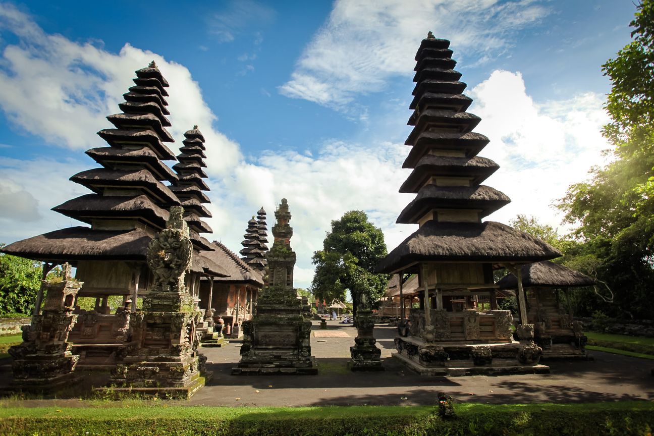 A visitor walks through a traditional Balinese temple complex