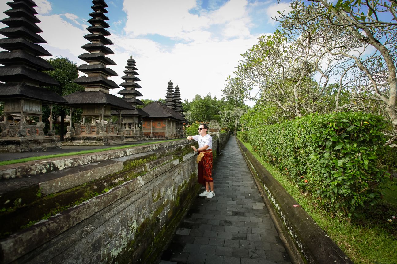 A visitor walks through a traditional Balinese temple complex