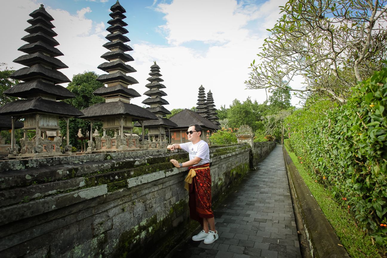 A visitor walks through a traditional Balinese temple complex