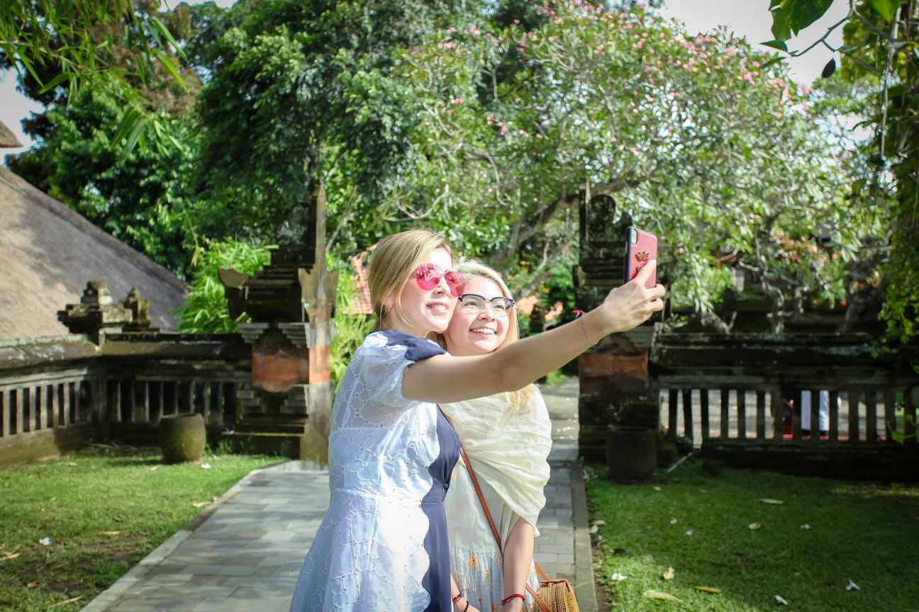 Travellers take photographs together in a Balinese temple garden