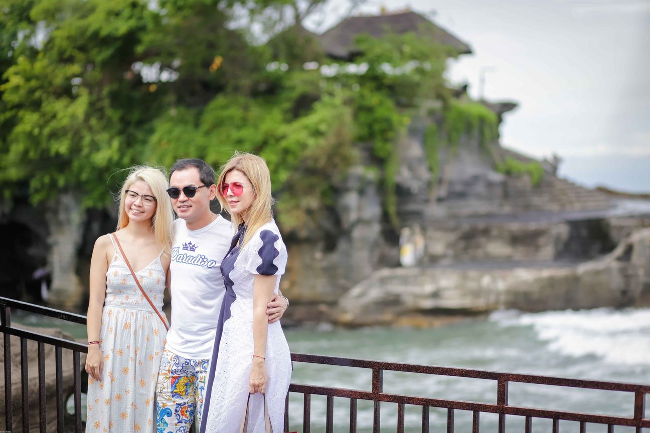 Three travellers share portraits at a rocky coastal viewpoint