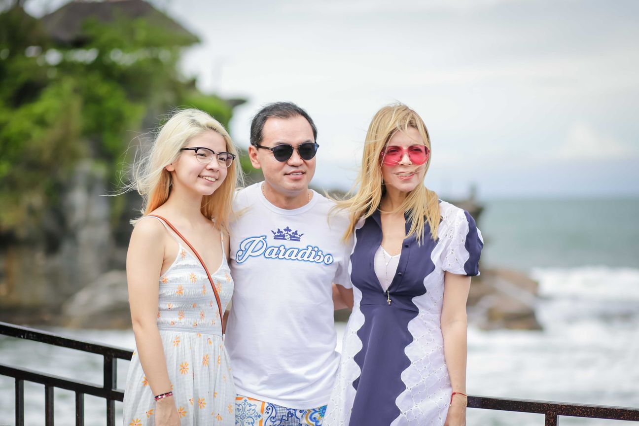 Three travellers share portraits at a rocky coastal viewpoint