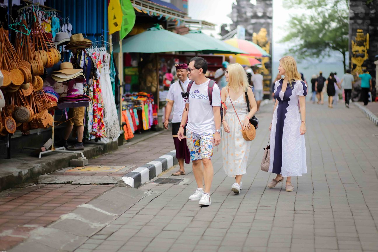 Travellers walk together through gardens and village streets in Bali