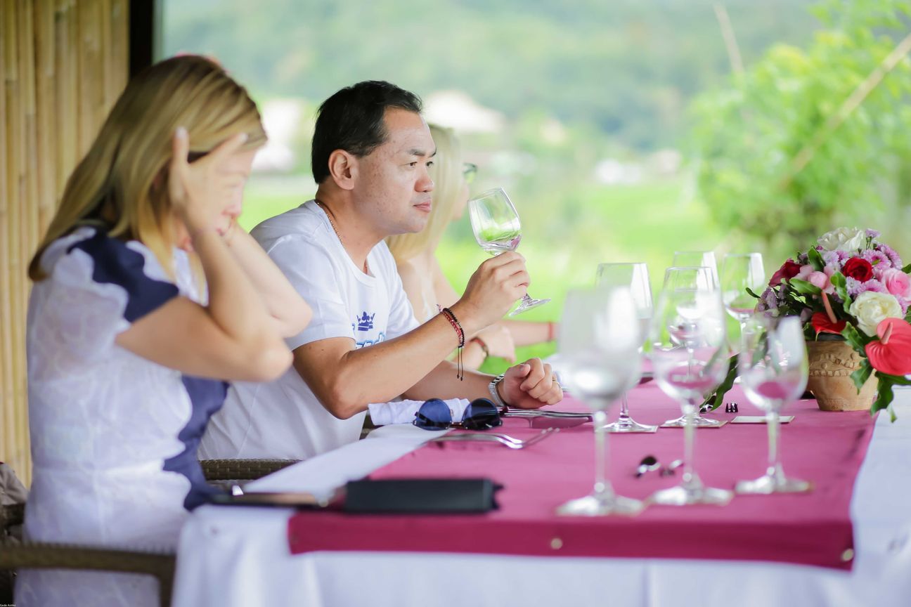 Travellers talk and eat around a table overlooking rice terraces