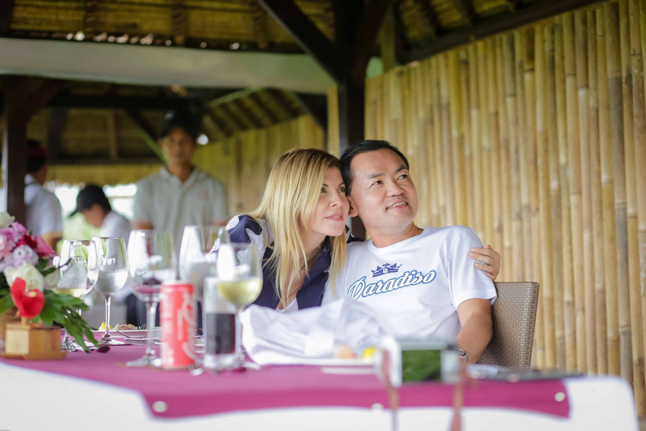 Travellers talk and eat around a table overlooking rice terraces