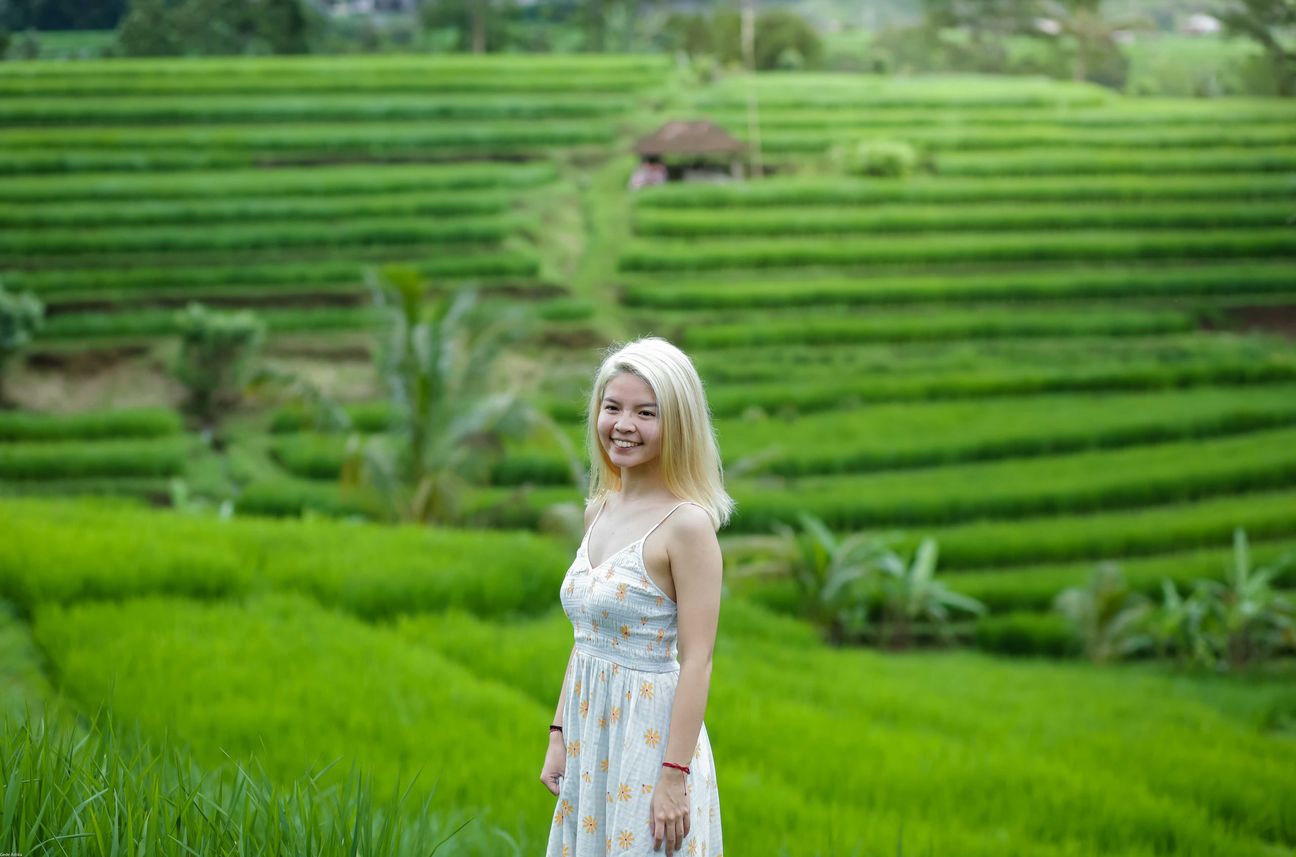 Travellers pose among layered green rice fields in Bali