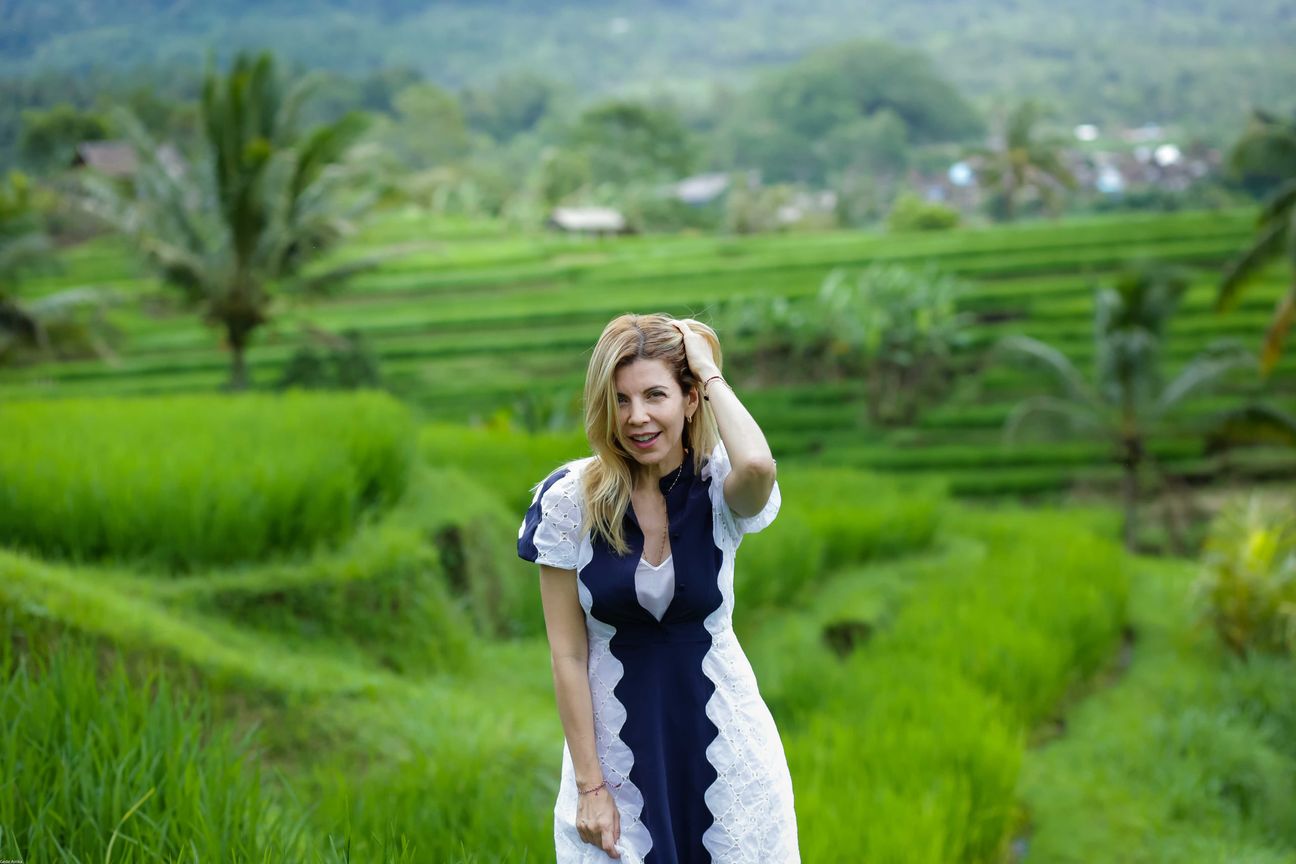 Travellers pose among layered green rice fields in Bali