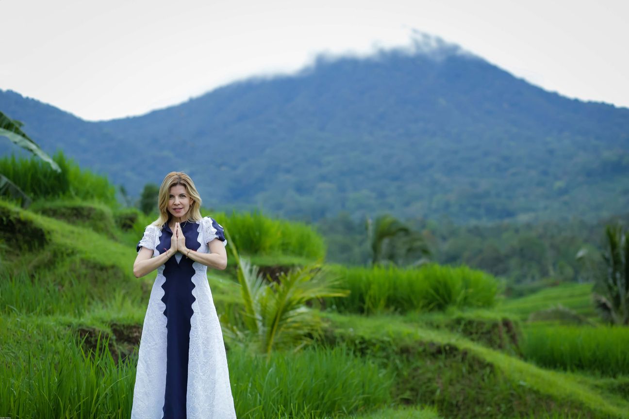 Travellers pose among layered green rice fields in Bali