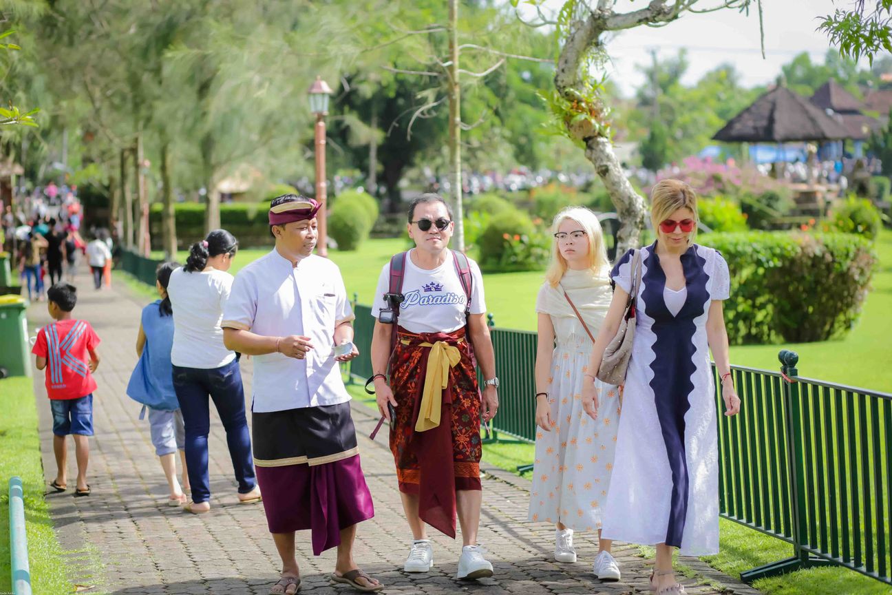 Travellers explore stone paths, shrines and courtyards at a Balinese temple