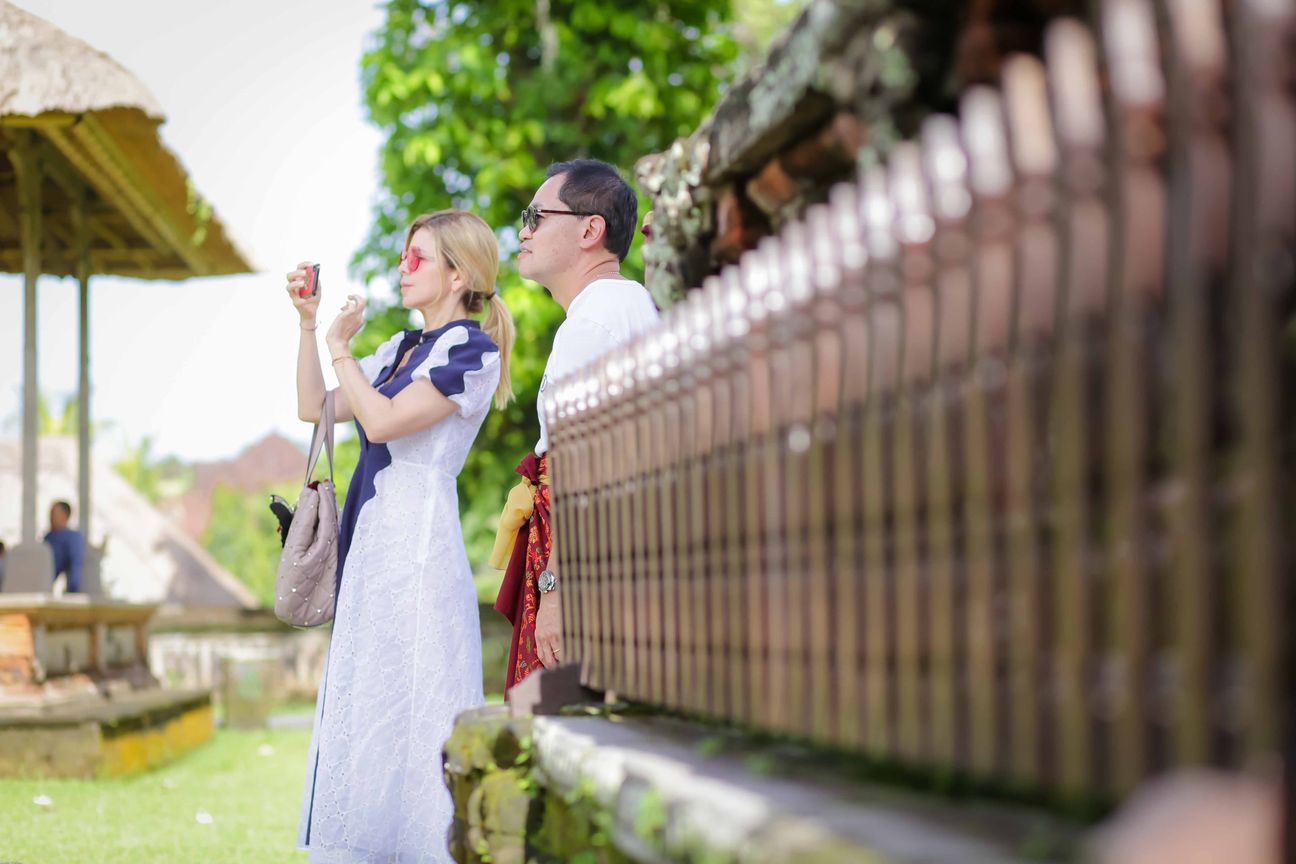Travellers explore stone paths, shrines and courtyards at a Balinese temple