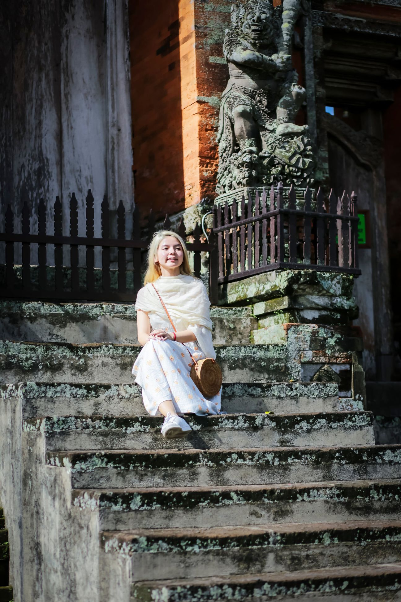 Travellers explore stone paths, shrines and courtyards at a Balinese temple