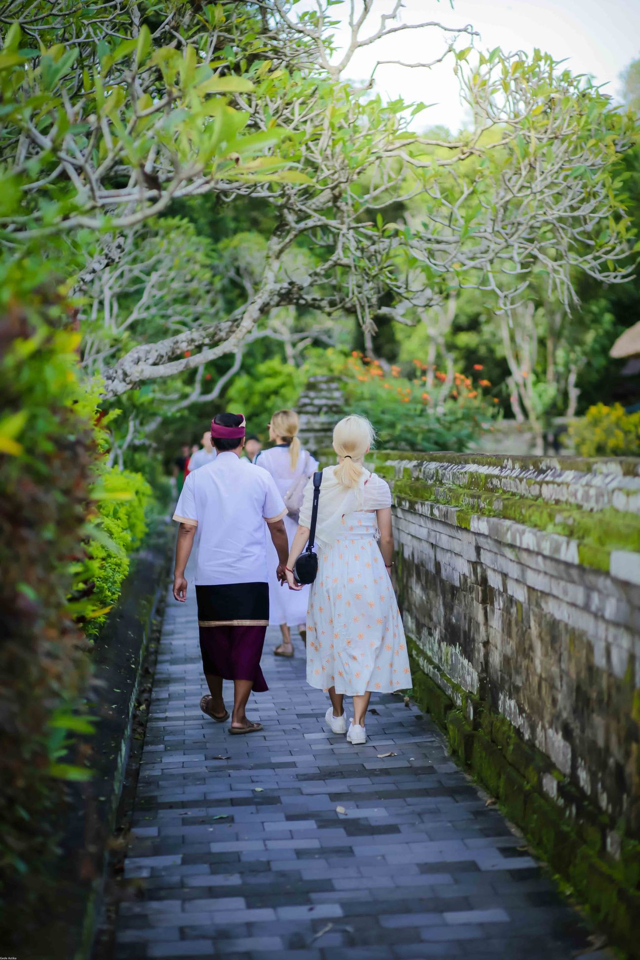 Travellers explore stone paths, shrines and courtyards at a Balinese temple