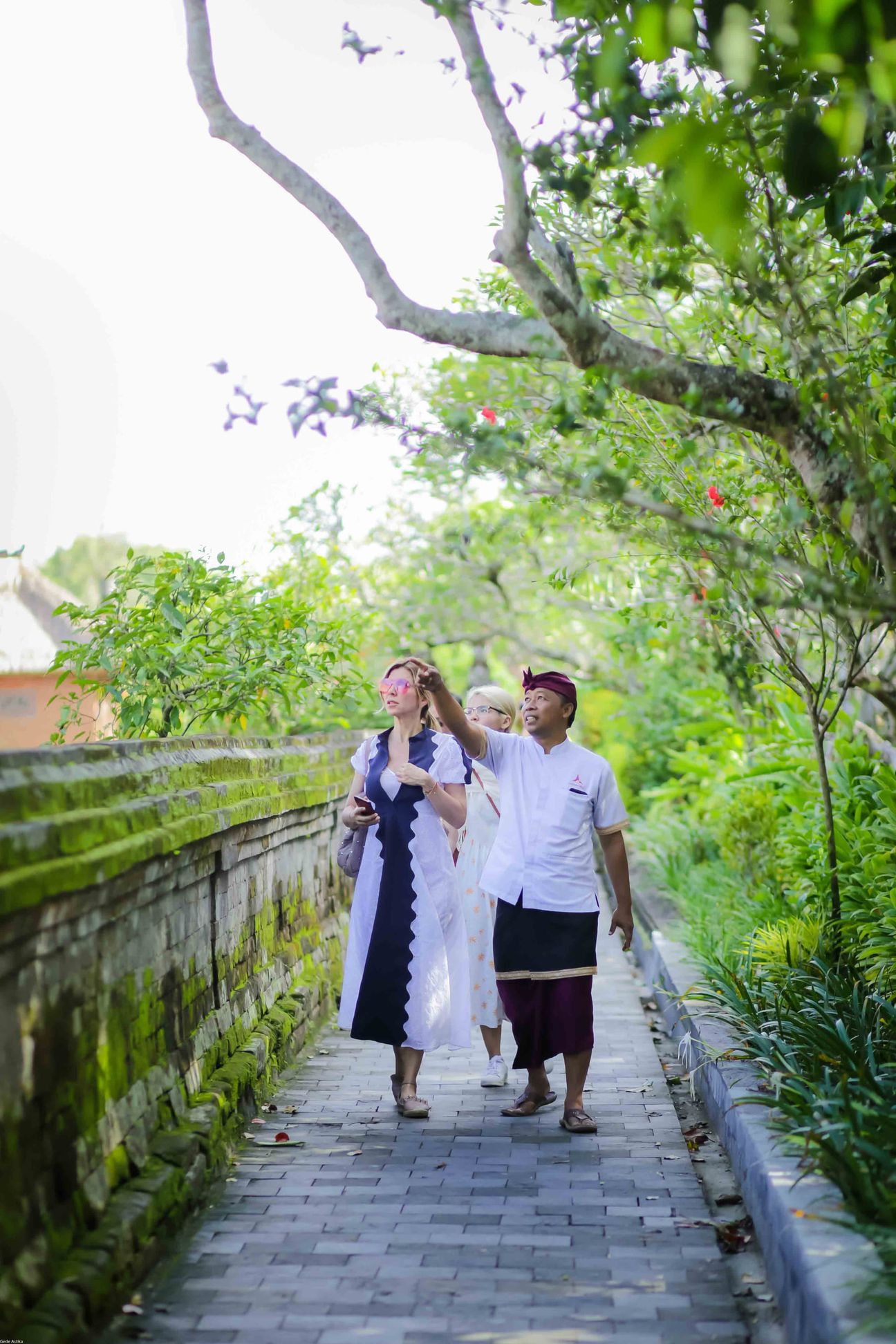 Travellers explore stone paths, shrines and courtyards at a Balinese temple