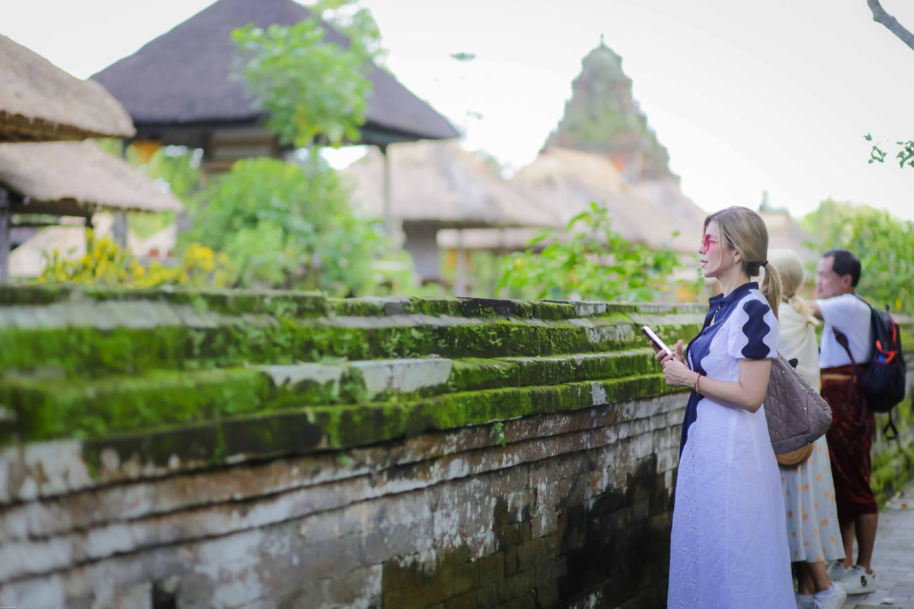 Travellers explore stone paths, shrines and courtyards at a Balinese temple