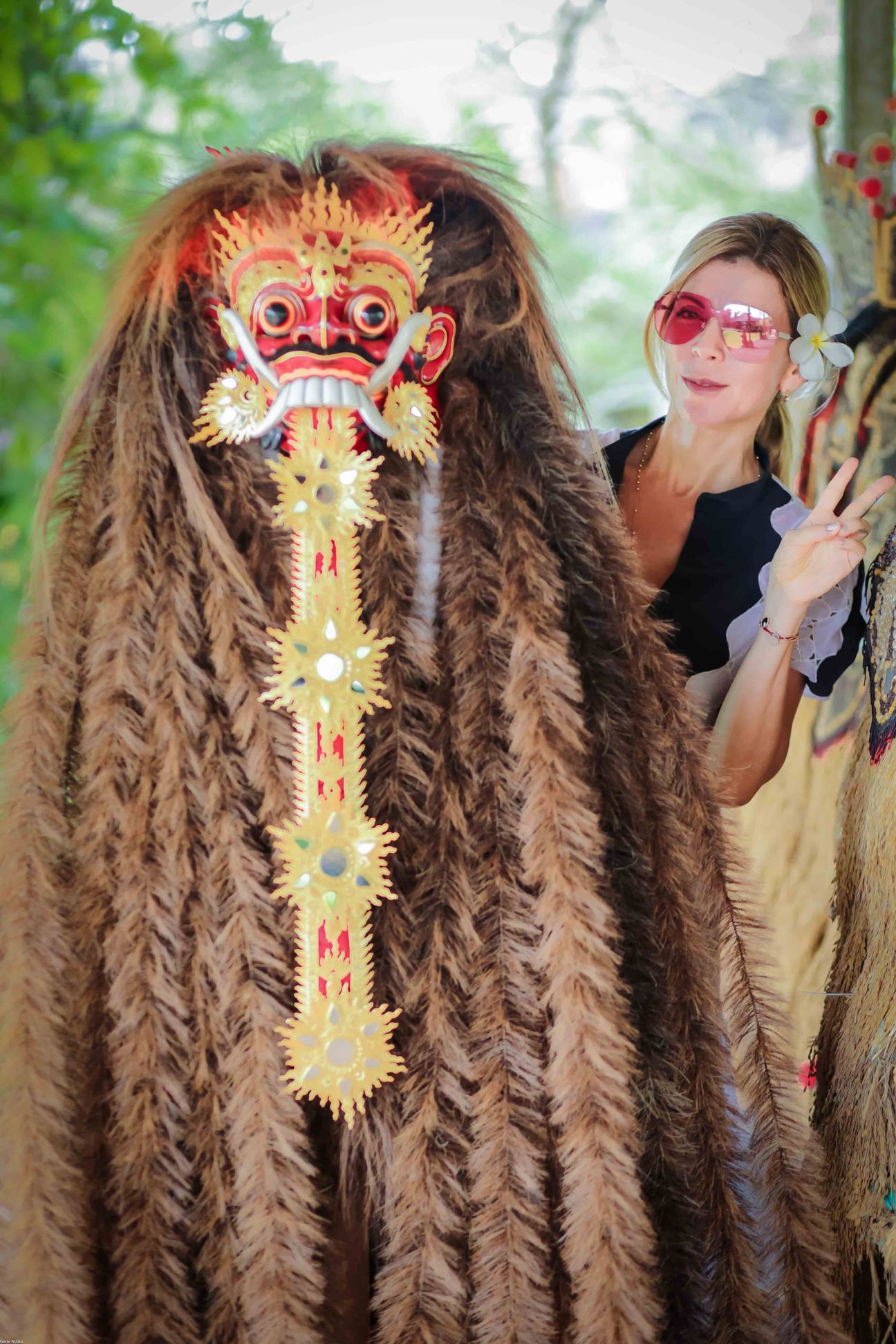 A traveller stands beside a ceremonial Barong figure