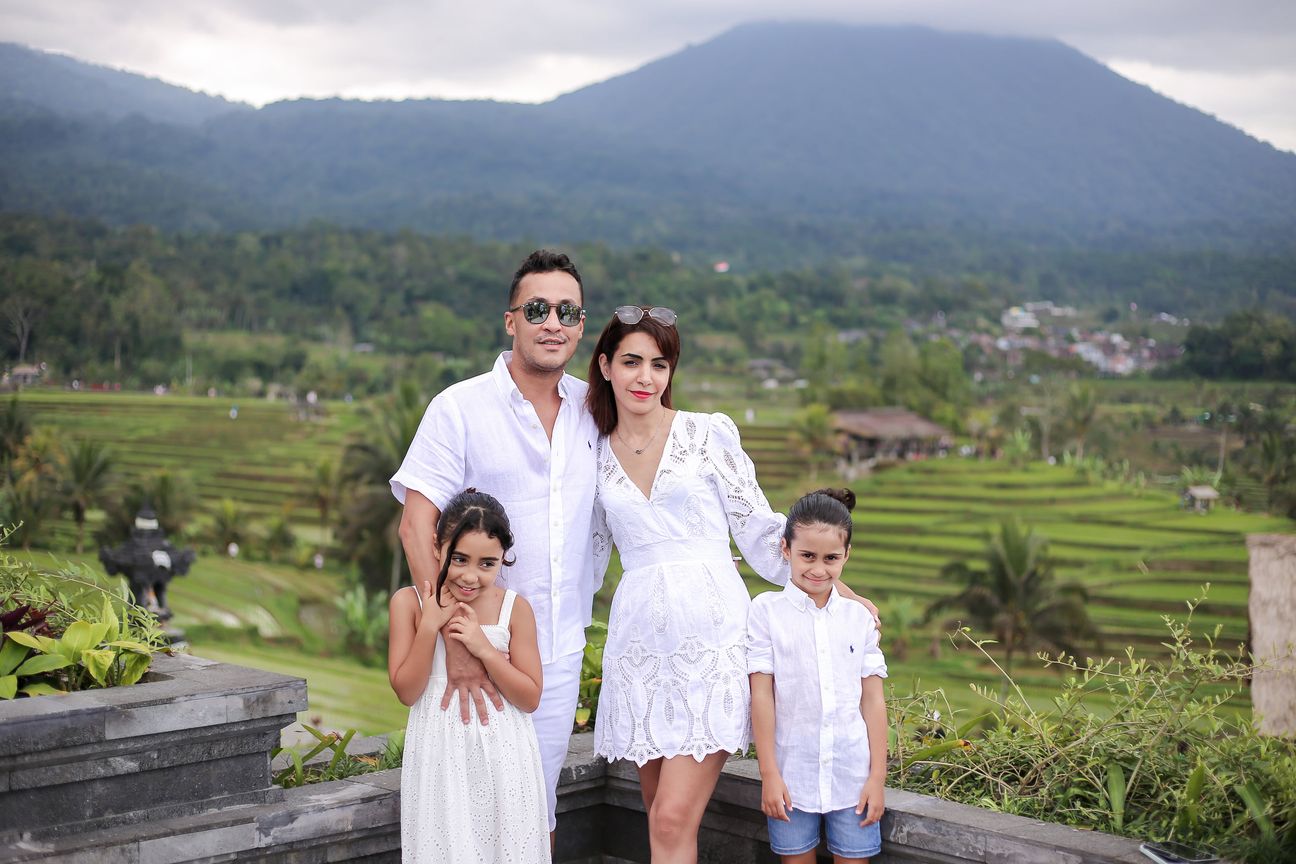 A family of four dressed in white pose together among the rice terraces