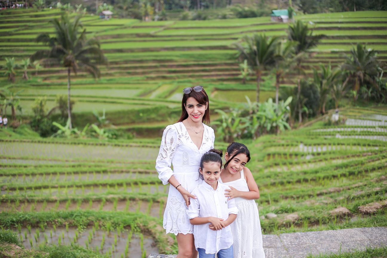 A family of four dressed in white pose together among the rice terraces
