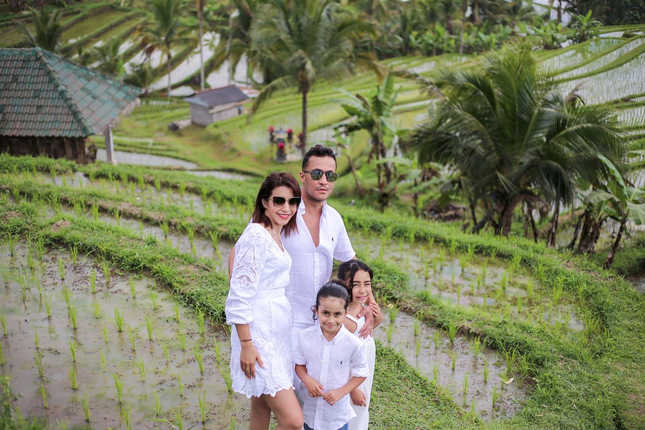 A family of four dressed in white pose together among the rice terraces